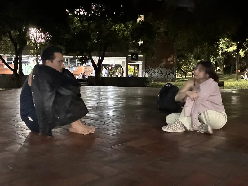 Dos integrantes descalzos improvisan de noche en la plaza de la universidad